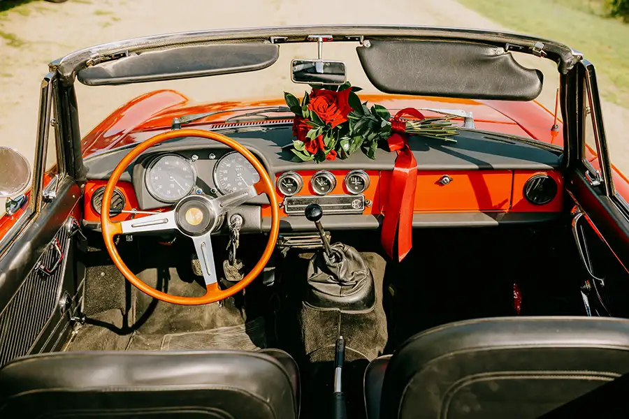 Alfa Romeo Spider vintage convertible interior decorated with red roses for a wedding